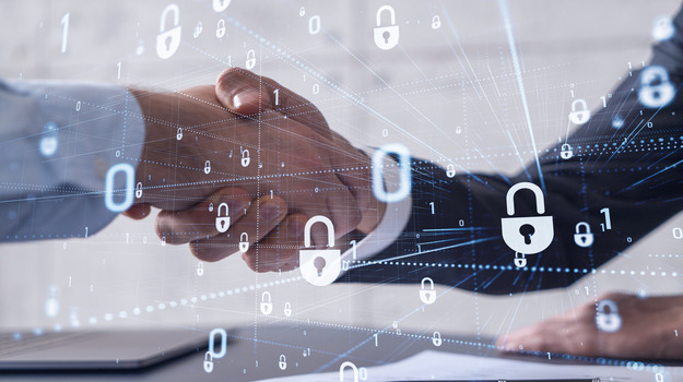 Handshake of two businessmen who enters into the contract to protect cyber security of international company. Padlock Hologram icons over the table with documents. stock photo