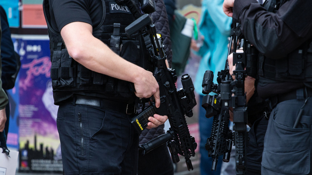 leeds, United Kingdom – May 05, 2019: Horizontal shot of armed police patrolling tour de yorkshire crowd to keep everyone safe