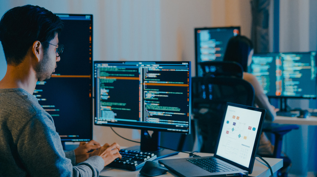 Group Adult Asia male, female freelance typing write prompt AI bot IT app smart program nomad, video game, terminal with coding language, designer, big data center on desktop computer in night office.